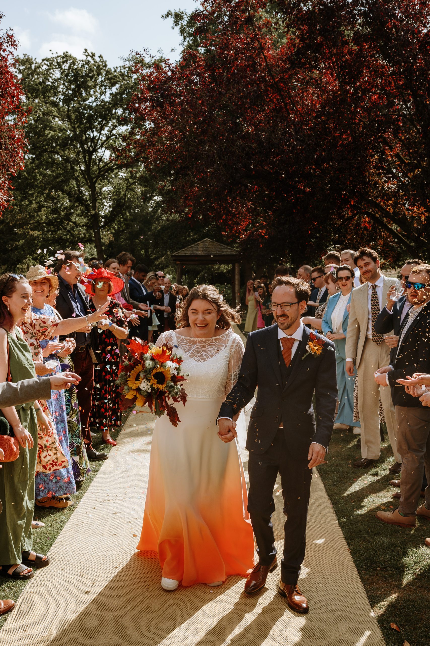 Sophie and husband Kurtis walking down the aisle at their wedding with confetti being thrown.
